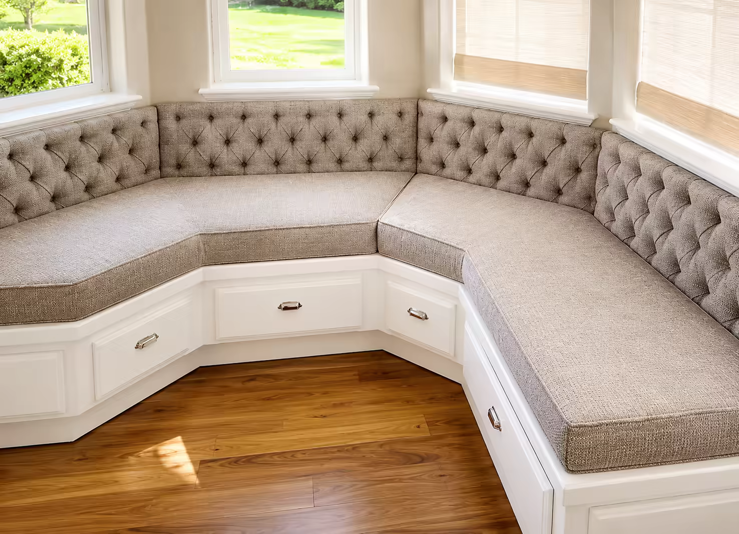 A custom tufted bay-window banquette upholstered in linen